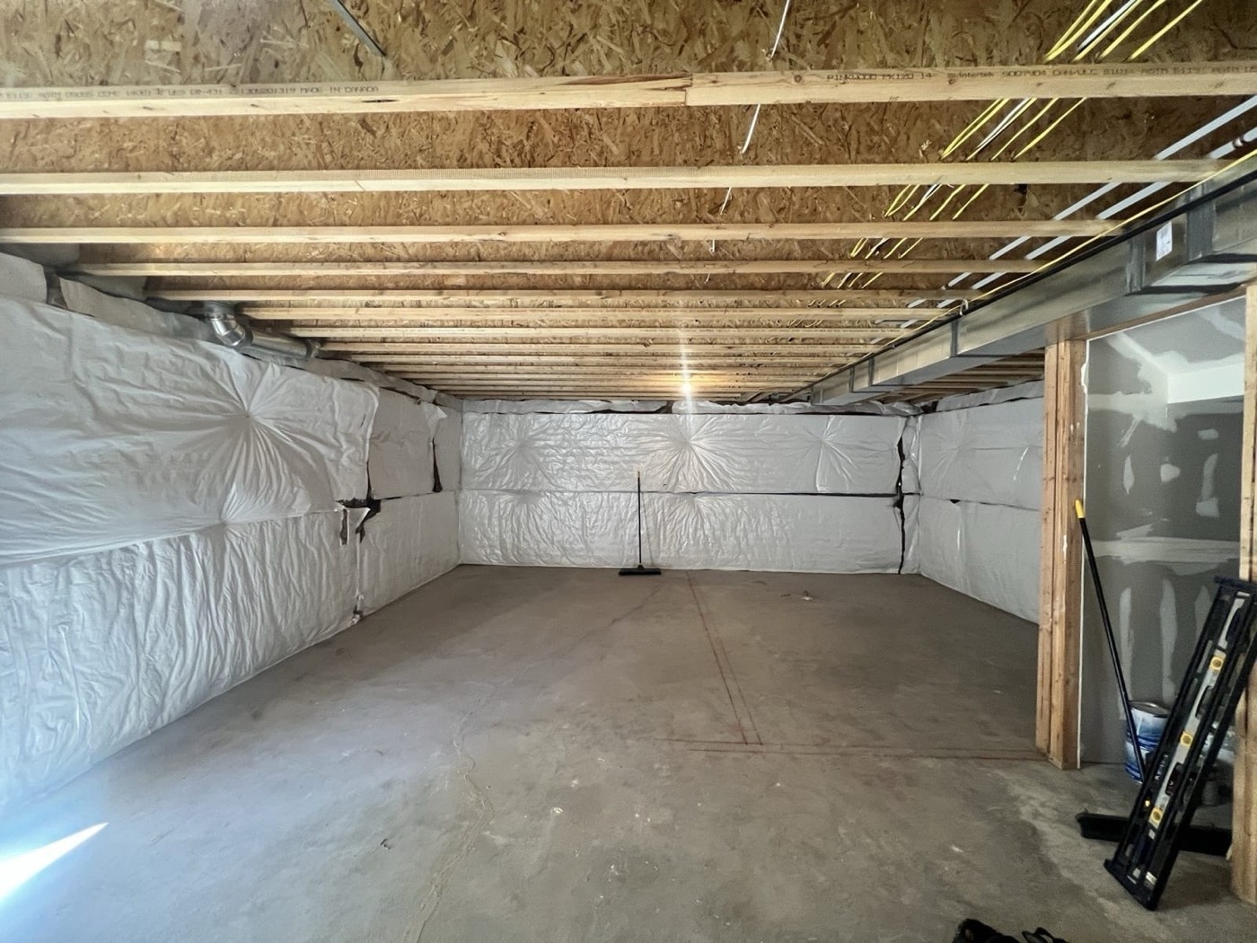 Unfinished basement with exposed framing and concrete floor — before Rocky Mtn Remodel