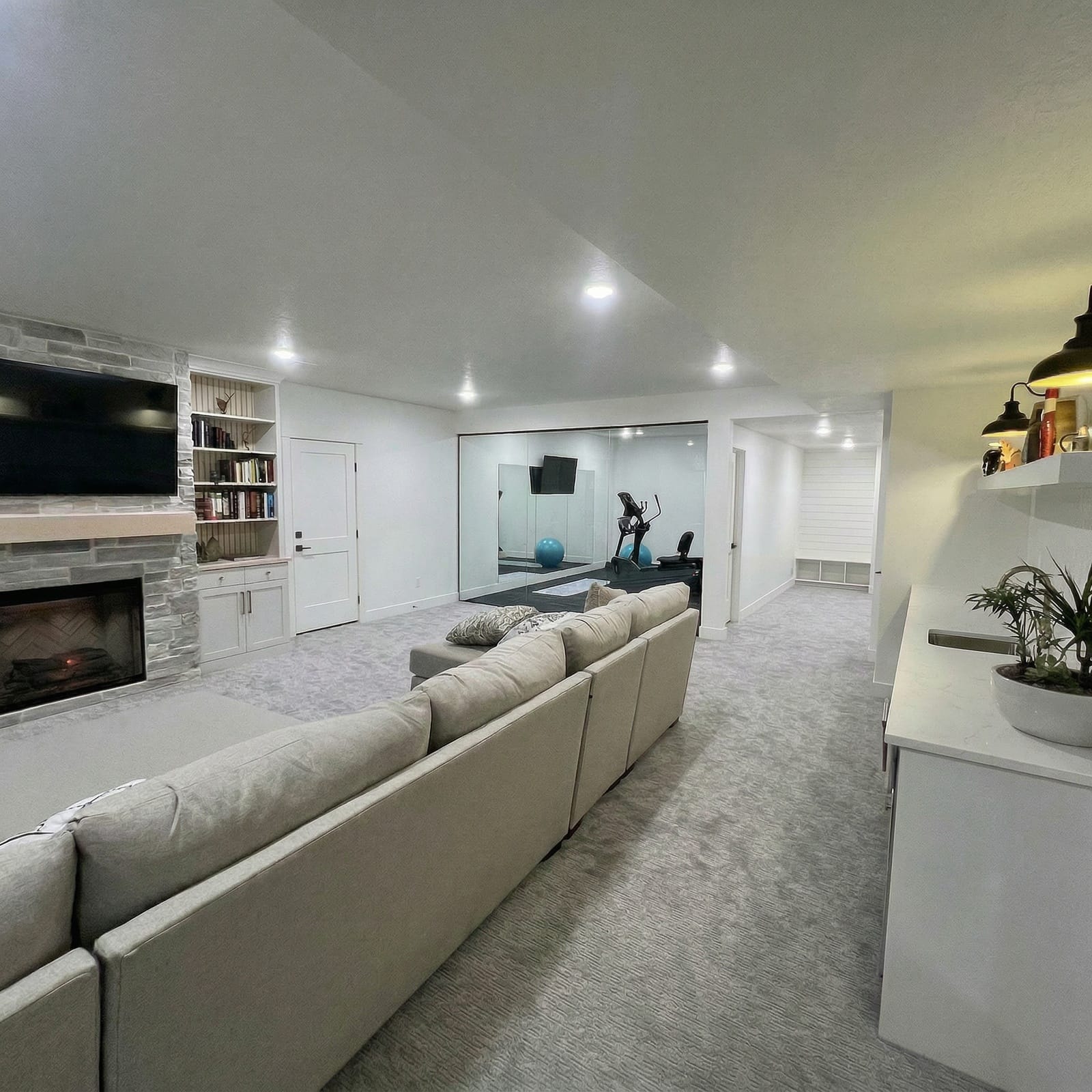 Finished basement with open family room, LVP flooring and recessed lighting — Rocky Mtn Remodel Utah County